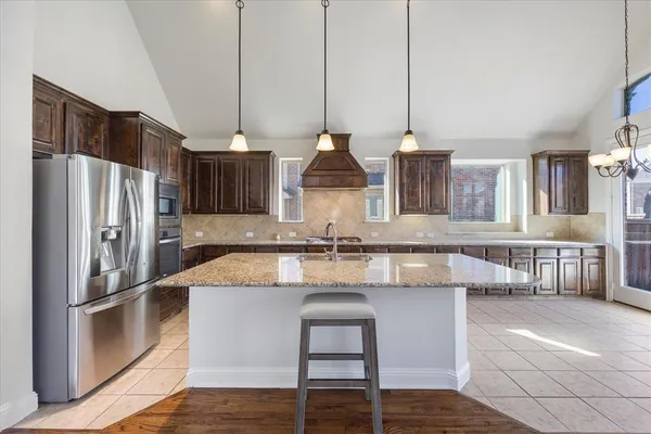 a kitchen with stainless steel appliances granite countertop a sink a stove and a refrigerator