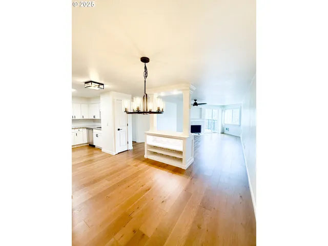 a view of empty room with wooden floor and fireplace