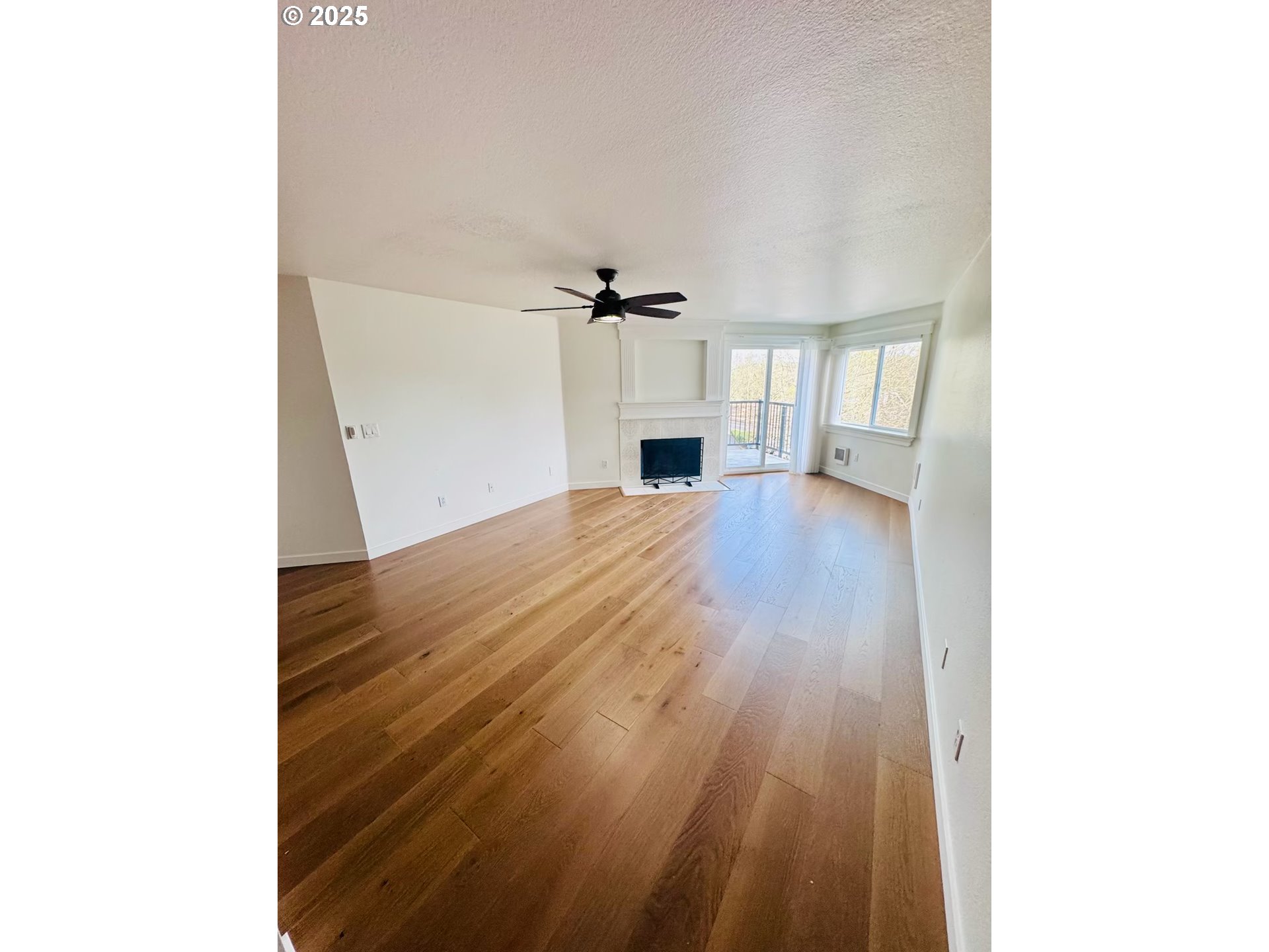 8720 Southwest Tualatin Road, Unit 315 Tualatin, OR 97062 - Photo 5 of 41 a view of a livingroom with wooden floor a fireplace and windows