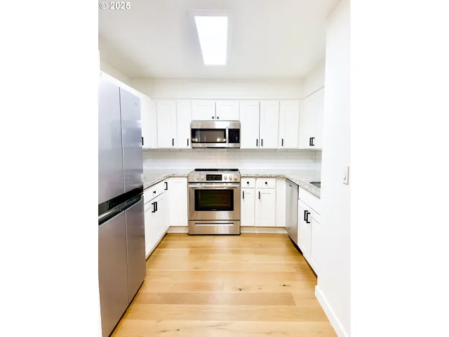 a kitchen with stainless steel appliances a stove a sink and a microwave