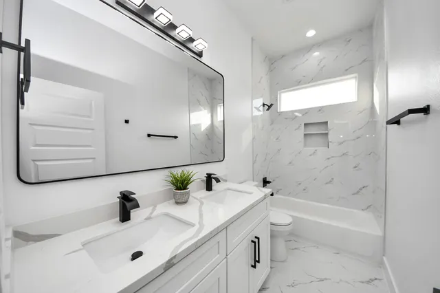 a bathroom with a sink a toilet and shower