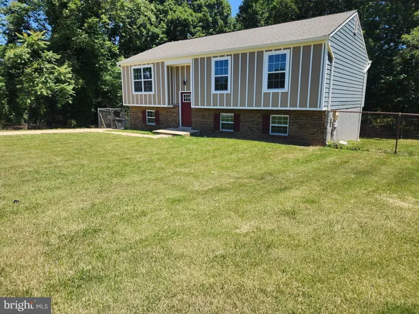a front view of house with yard and trees in the background