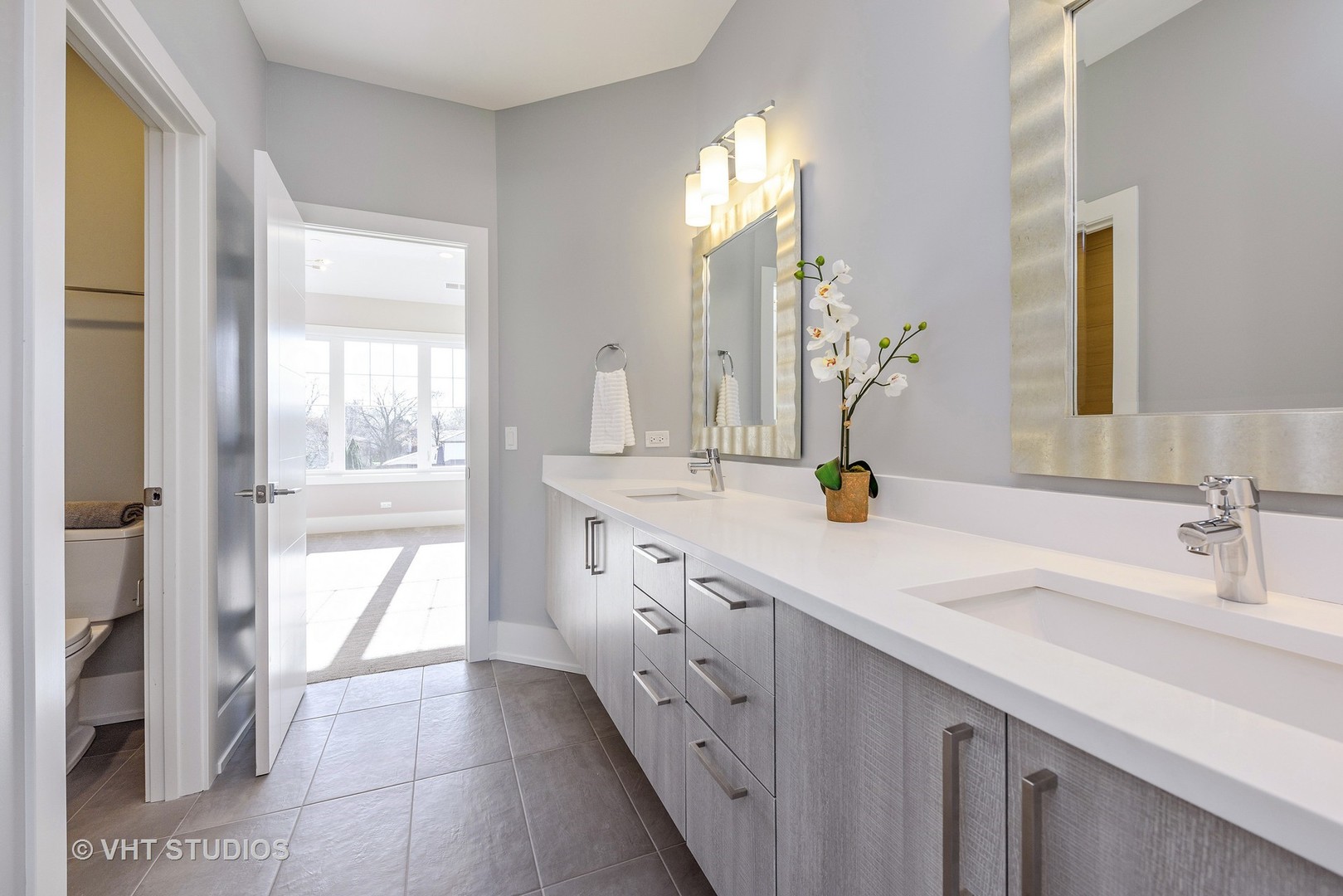 2709 Walters Avenue Northbrook, IL 60062 - Photo 27 of 33 a bathroom with double vanity and a mirror