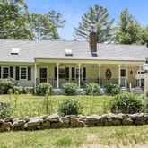 a front view of a house with a yard and potted plants