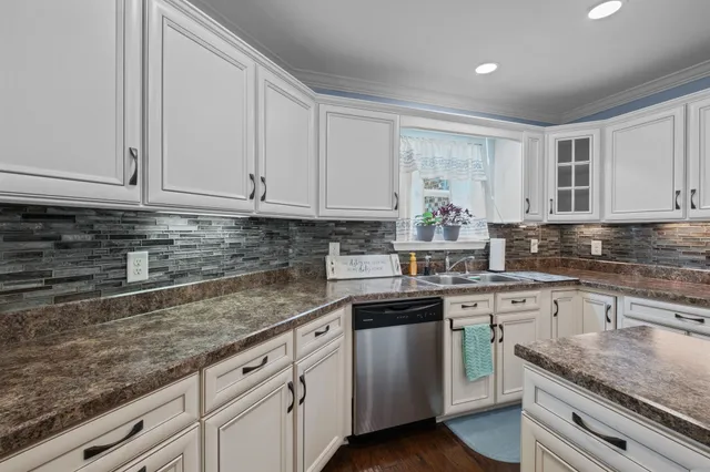 a kitchen with granite countertop white cabinets and white stainless steel appliances