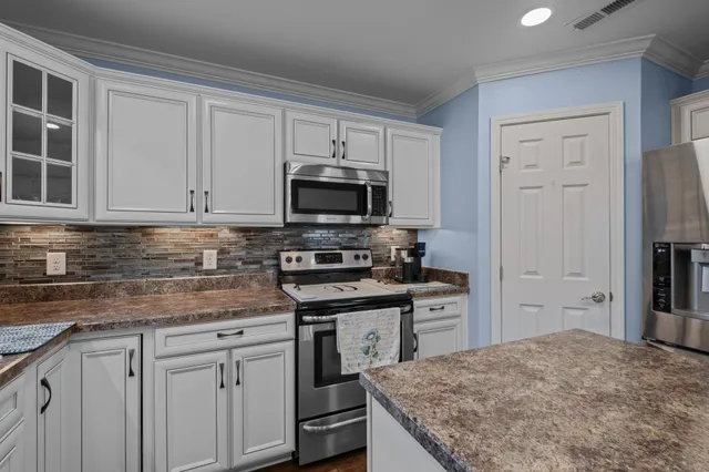 a kitchen with cabinets appliances and a counter space