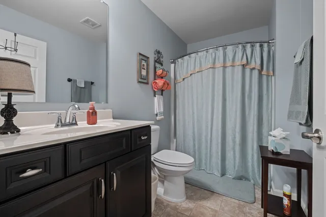 a bathroom with a sink vanity mirror and toilet