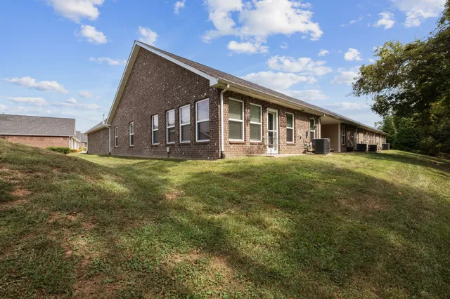 a view of a house with a big yard and large trees