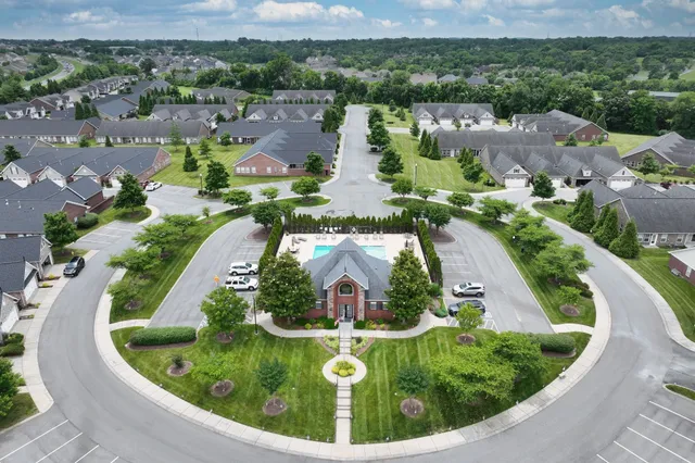 an aerial view of residential houses with outdoor space and parking
