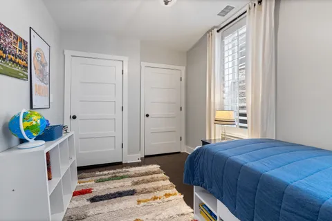 a bedroom with a bed a chandelier and closet