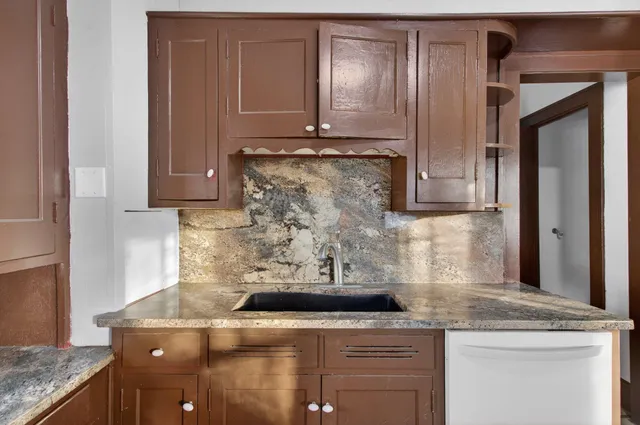 a kitchen with granite countertop white cabinets and white appliances