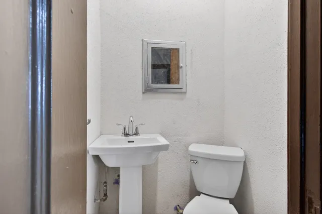 a bathroom with a toilet sink and mirror