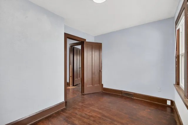an empty room with wooden floor and closet