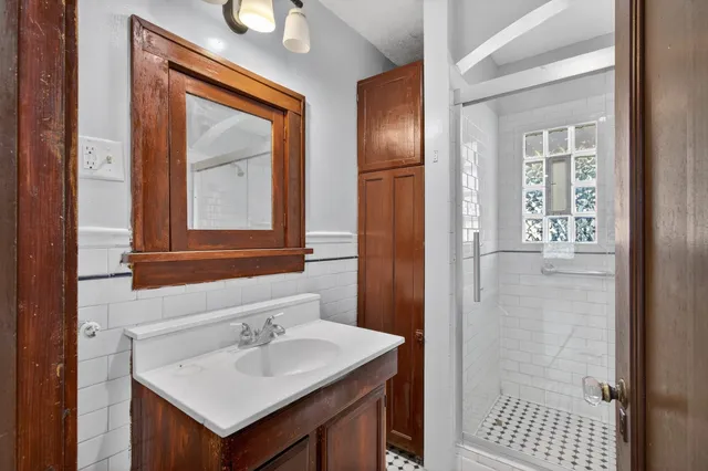 a bathroom with a sink a mirror and a shower