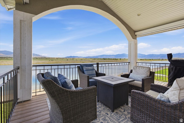 21 Pier Place Tooele, UT 84074 - Photo 83 of 112 Covered outdoor patio featuring an arched entryway, wood-finish flooring, black metal railings, and a direct water frontage