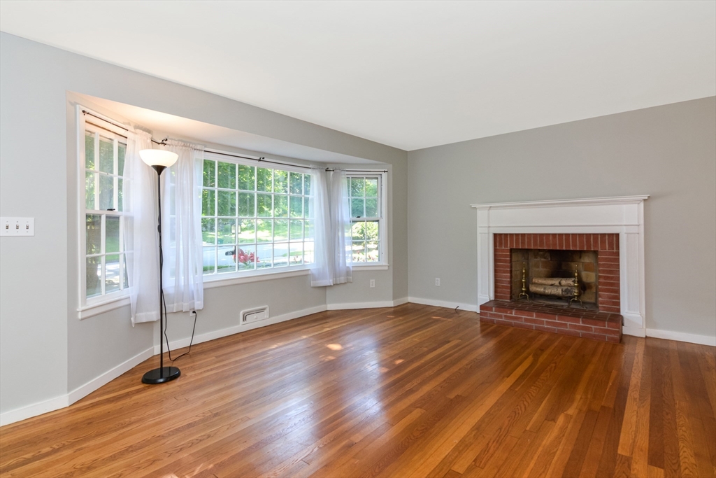 39 Beechmont Street Worcester, MA 01609 - Photo 4 of 42 a view of an empty room with wooden floor fireplace and a window