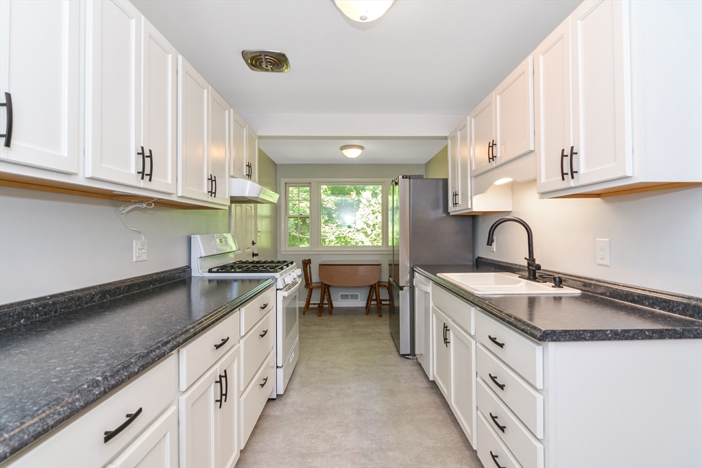 39 Beechmont Street Worcester, MA 01609 - Photo 7 of 42 a kitchen with granite countertop a sink dishwasher a stove and a refrigerator with wooden cabinets
