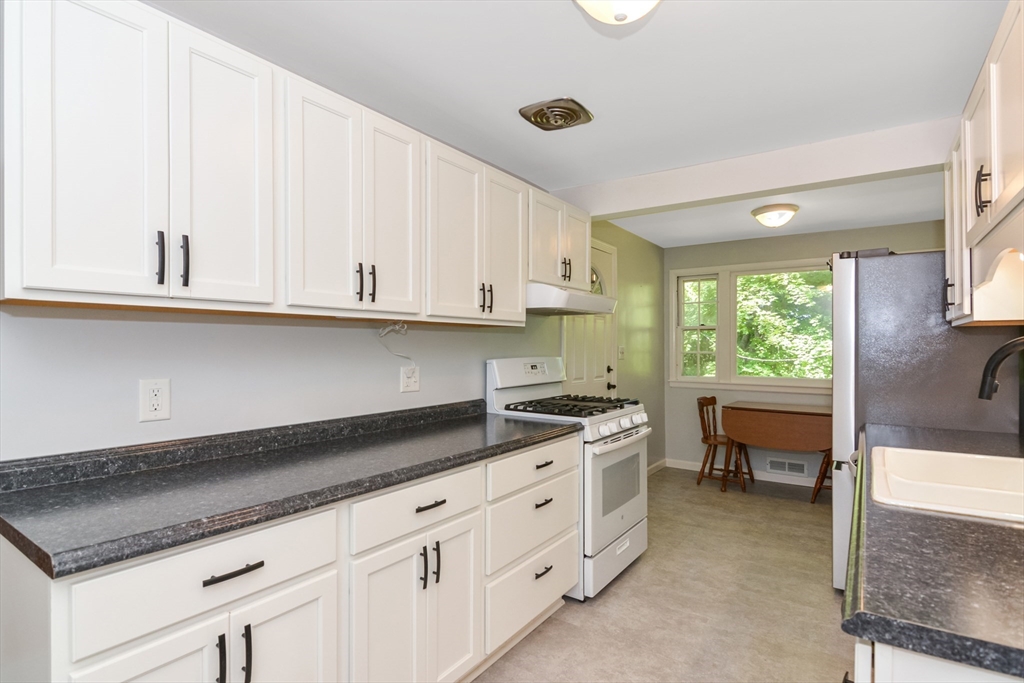 39 Beechmont Street Worcester, MA 01609 - Photo 9 of 42 a kitchen with granite countertop white cabinets and white appliances