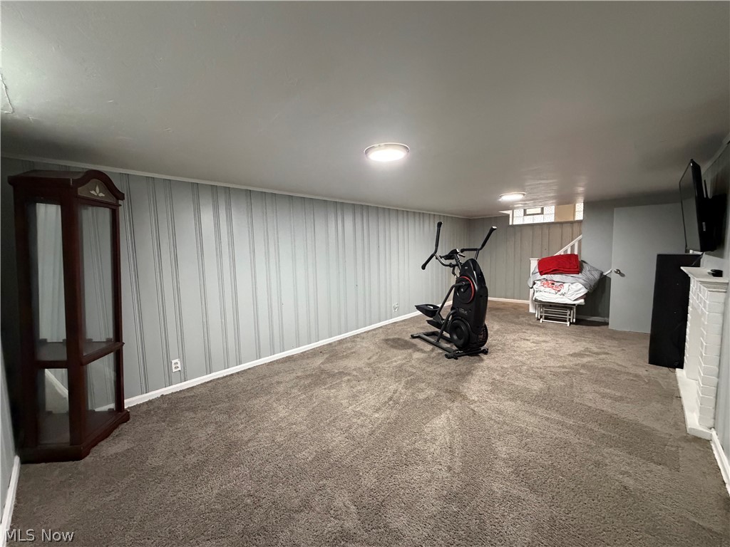 3714 Avalon Road Shaker Heights, OH 44120 - Photo 37 of 46 Spacious lower-level room featuring durable carpet flooring, light-colored vertical paneling, and a painted fireplace with a mantel