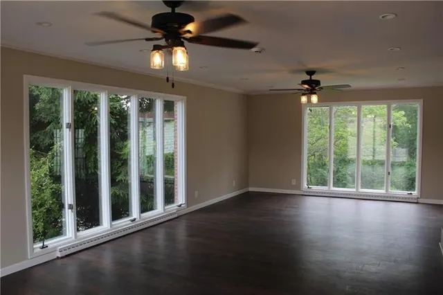 an empty room with wooden floor and windows