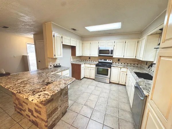 a kitchen with a stove a sink and a refrigerator