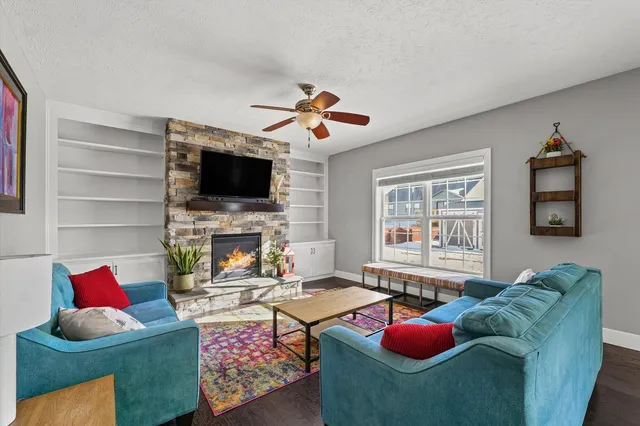 a living room with furniture a flat screen tv and a fireplace