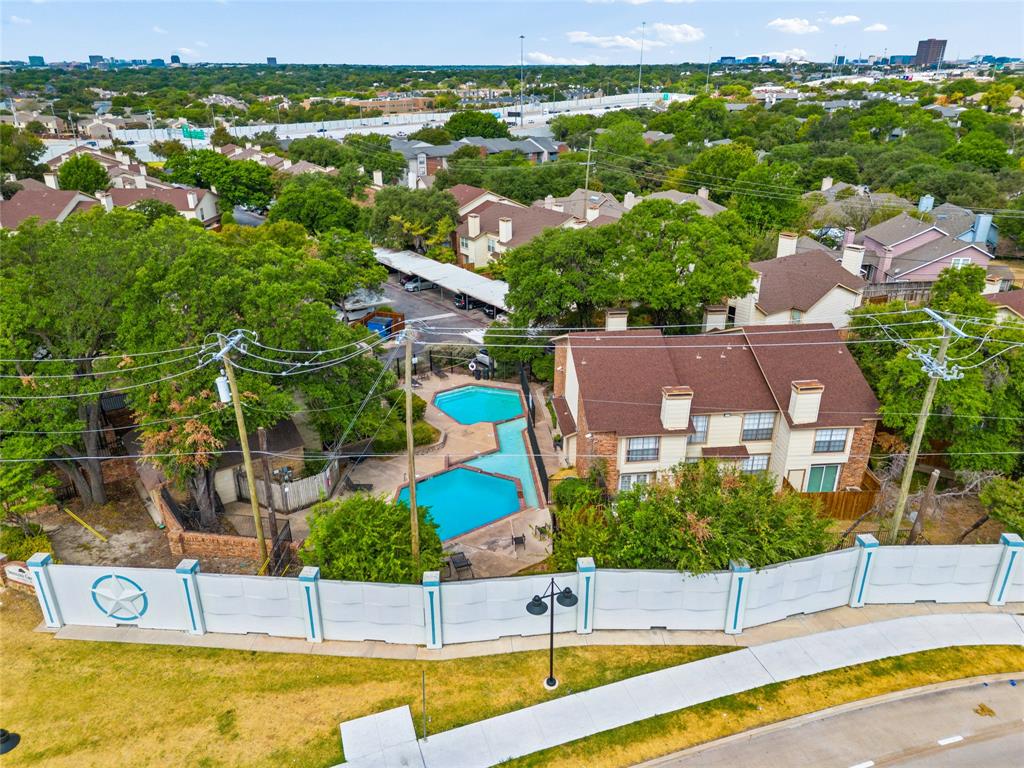11311 Audelia Road, Unit 102 Dallas, TX 75243 - Photo 31 of 31 Expansive backyard oasis featuring a resort-style saltwater pool with curved design, surrounding patio decking, mature landscaping with established trees, and white safety fencing