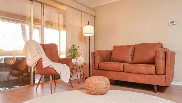 a living room with furniture and a floor to ceiling window