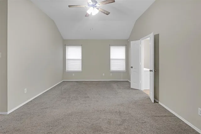 an empty room with chandelier fan