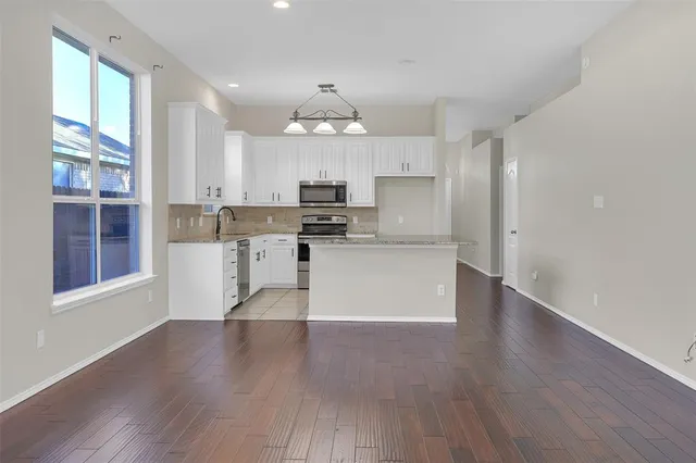 a view of kitchen with granite countertop cabinets and wooden floor