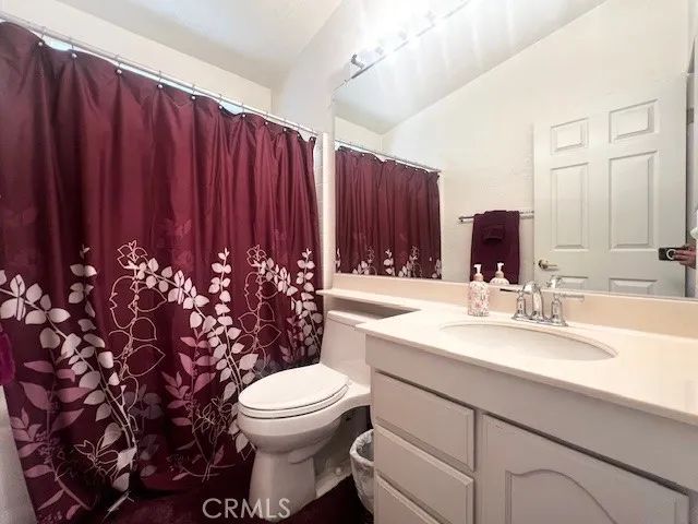 a bathroom with a sink a toilet and mirror