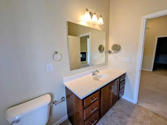 a bathroom with a toilet sink and mirror