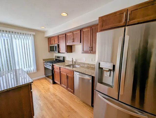 a kitchen with stainless steel appliances a refrigerator a stove a sink and a refrigerator