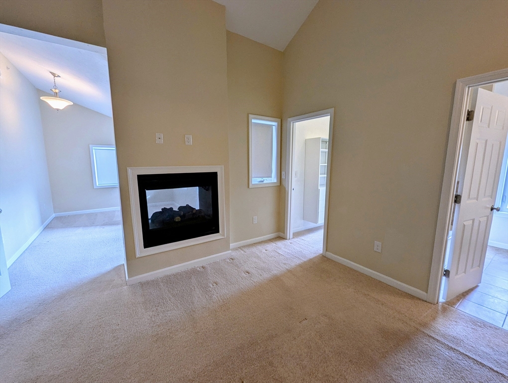 391 America Boulevard, Unit 391 Ashland, MA 01721 - Photo 9 of 22 a view of an empty room with a fireplace and a window