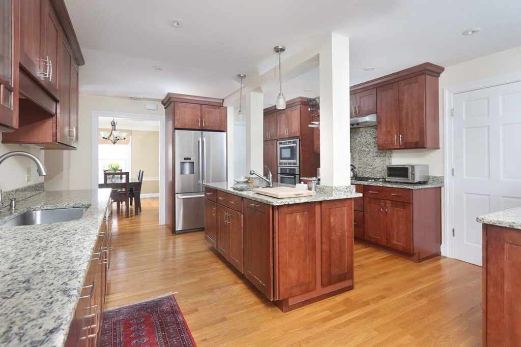 79 Evelyn Road Waban, MA 02468 - Photo 5 of 16 a kitchen with stainless steel appliances granite countertop a stove a sink dishwasher a refrigerator and a oven with wooden floor