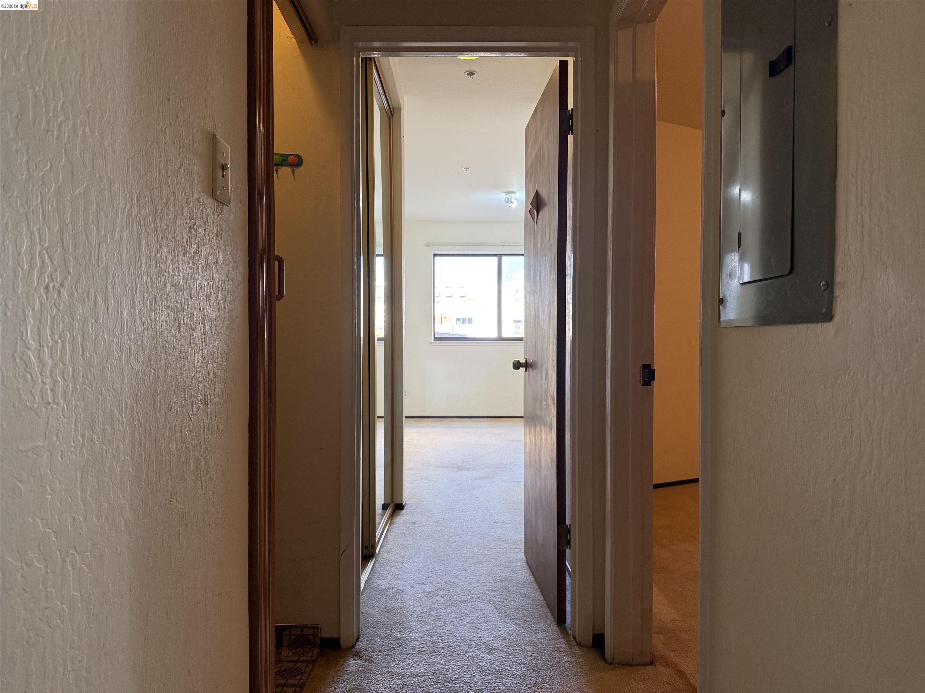 330 8th Street, Unit 3D Oakland, CA 94607 - Photo 13 of 13 Corridor featuring a textured wall, light carpet, and electric panel
