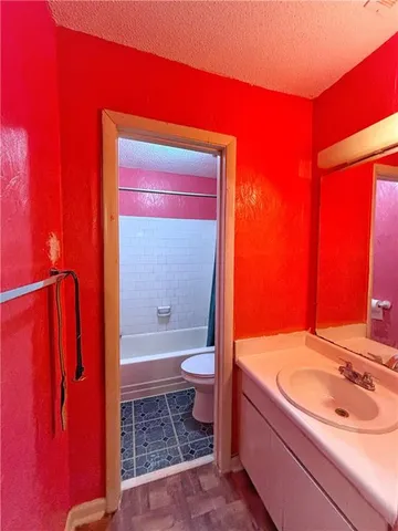 a bathroom with a granite countertop sink toilet and shower