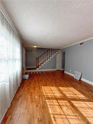 a view of an empty room with wooden floor