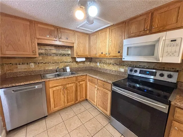 a kitchen with cabinets appliances and a sink