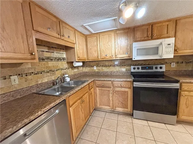 a kitchen with stainless steel appliances granite countertop a sink stove and cabinets