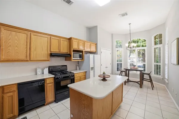 a kitchen that has a sink a stove top oven a counter space and cabinets