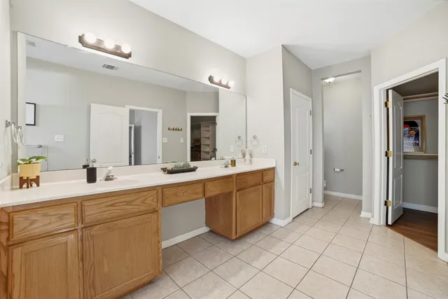 a large white bathroom with a double vanity sink mirror and a