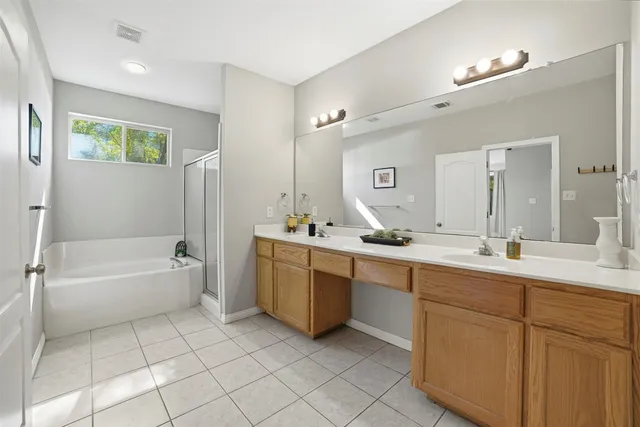 a bathroom with a tub a sink and mirror