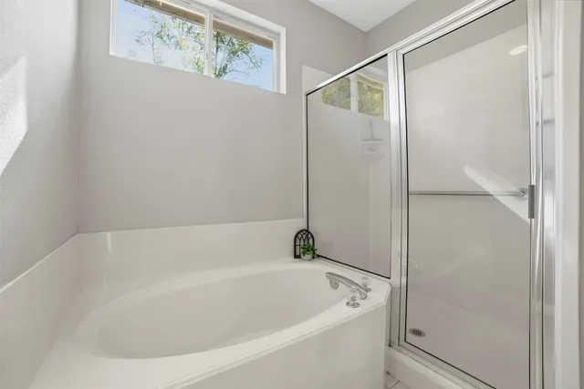 a white bath tub sitting next to a shower