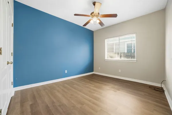 an empty room with windows and fan