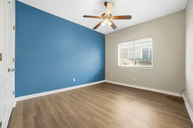 an empty room with windows and fan