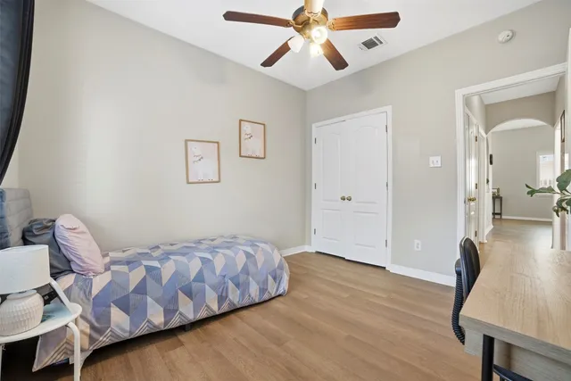 a bedroom with a bed and wooden floor