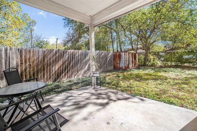 a backyard of a house with table and chairs