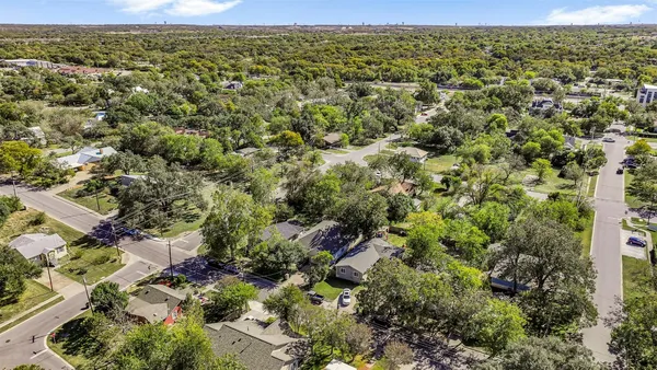 an aerial view of residential houses with outdoor space and trees