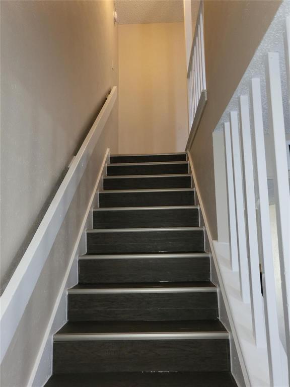 8005 Rothington Road, Unit 57 Dallas, TX 75227 - Photo 14 of 15 Stairway with a textured ceiling